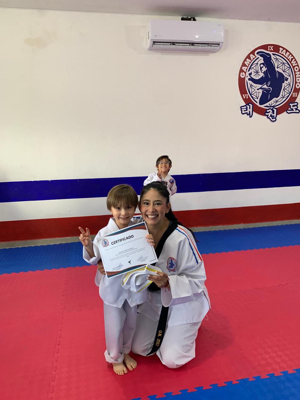 Instructora de GAMA Taekwondo entregando certificado a alumno en Monterrey Cumbres